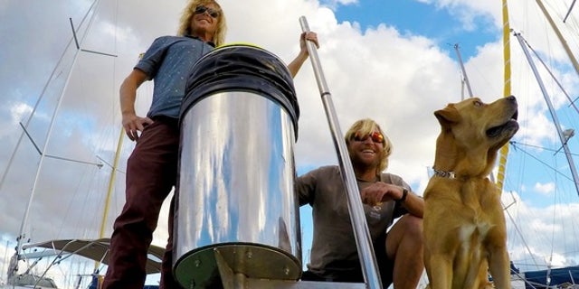 A photograph of the inventors with a prototype of their Seabin device.