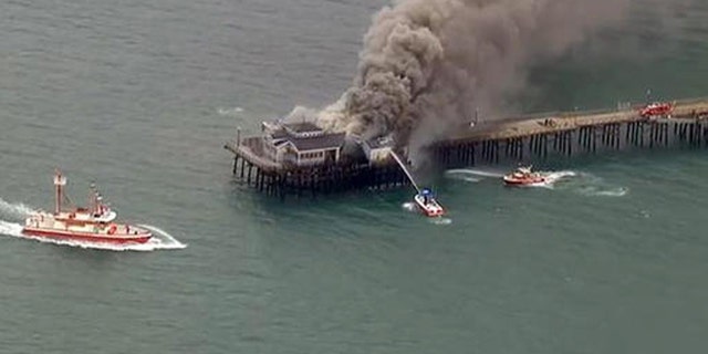 Firefighters attack a fire on the Seal Beach pier in Seal Beach, Calif. on Friday, May 20, 2016. (KABC-TV via AP)