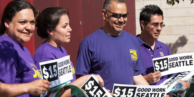 Labor activists celebrate during a rally at Seattle City Hall after a Seattle City Council meeting in which the council voted on raising the minimum wage to $15.00 per hour in Seattle, Washington June 2, 2014. The Seattle city council voted unanimously on Monday to approve a sharp increase in the city's minimum wage to $15 an hour over the next seven years, marking the first time a major U.S. city has committed to such a high base level of pay. REUTERS/David Ryder (UNITED STATES - Tags: BUSINESS EMPLOYMENT) - RTR3RX17