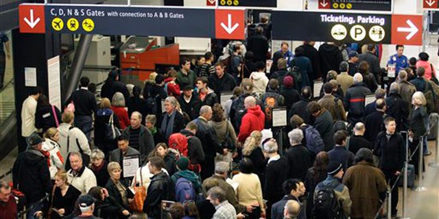 In this file photo taken Dec. 27, 2010, travelers wait in a TSA security checkpoint line at Seattle-Tacoma International Airport.