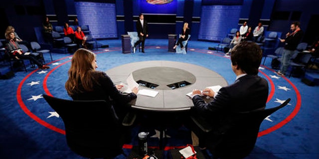 Students stand in on the stage as preparations are made for the second presidential debate between Republican presidential nominee Donald Trump Democratic presidential nominee Hillary Clinton at Washington University in St. Louis, Saturday, Oct. 8, 2016. (AP Photo/Julio Cortez)