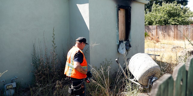 A worker clears debris after Sunday's deadly fire in Vallejo, Calif.