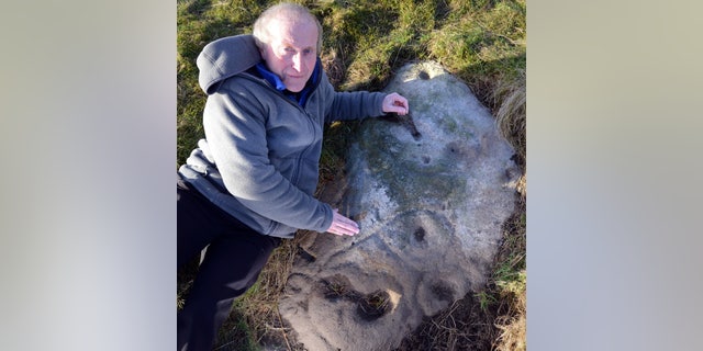 Gordon Holmes on Baildon Moor with what he believes is a Stone Age selfie of a person under the symbol for Cassiopeia.