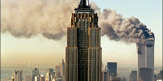 The twin towers of the World Trade Center are shown burning behind New York's Empire State Building in this Sept. 11, 2001, file photo. 