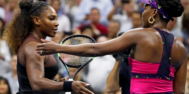 Serena Williams, left, meets her sister Venus Williams after their match during the third round of the U.S. Open tennis tournament, in Flushing, N.Y., Aug. 31, 2018.