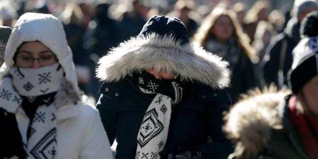 Pedestrians try to keep warm while walking in New York's Times Square, Wednesday, Dec. 27, 2017.