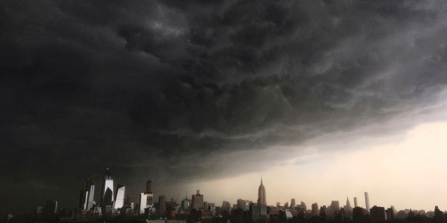 In this Tuesday, May 15, 2018 photo, storm clouds gather over New York city seen from the Hudson River. A line of strong storms pushed across New York City and generated a small tsunami off the coast.