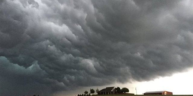 Storm clouds appear over a home near Meers, Okla., Tuesday, April 26, 2016. Strong thunderstorms capable of dropping grapefruit-sized hail and producing a few intense tornadoes popped up across the central U.S. on Tuesday after forecasters warned that millions of people faced a significant danger. (Robert MacDonald via AP) MANDATORY CREDIT