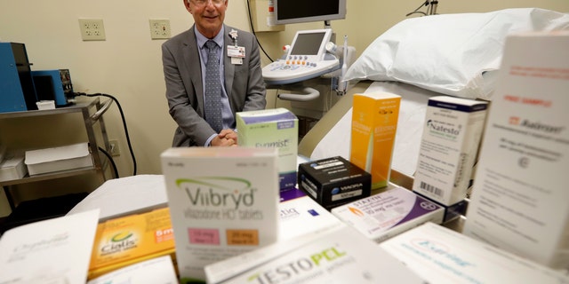 In this Tuesday, Nov. 29, 2016 photo, Dr. Irwin Goldstein poses in his office in San Diego behind a display of medicine for impotence and for sexual problems. For couples who can't afford the soaring prices for the prescriptions, some take a big risk, buying "herbal Viagra" at gas stations or ordering Viagra online from "Canadian pharmacies" that likely sell counterfeit drugs made in poor countries, says Goldstein, director of San Diego Sexual Medicine. (AP Photo/Gregory Bull)
