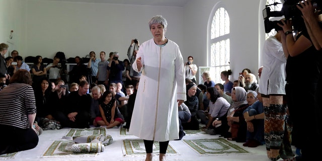 Seyran Ates, standing at center, founder of the Ibn-Rushd-Goethe-Mosque gestures during the opening of the mosque in Berlin, Germany, Friday, June 16, 2017.