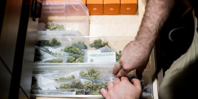JP Noda stocks cannabis at The Apothecarium shortly before the store opened for its first day of recreational marijuana sales on Saturday, Jan. 6, 2018, in San Francisco.