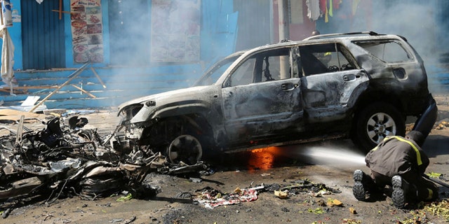 A firefighter tries to extinguish fire after an attack on a restaurant by the militant group al Shabaab.