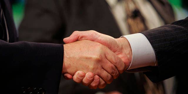 United Auto Workers President Ron Gettelfinger, left, and General Motors Chairman and CEO Rick Wagoner shake hands to open their contract talks at the UAW/GM Center for Human Resources in Detroit, Monday, July 23, 2007. The national contract between the UAW and the automakers expires Sept. 14. (AP Photo/Carlos Osorio)