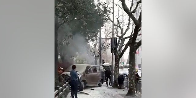 Rescuers attended to victims after a minivan carrying gas tanks plowed into pedestrians along a street in Shanghai, Friday, Feb. 2, 2018.