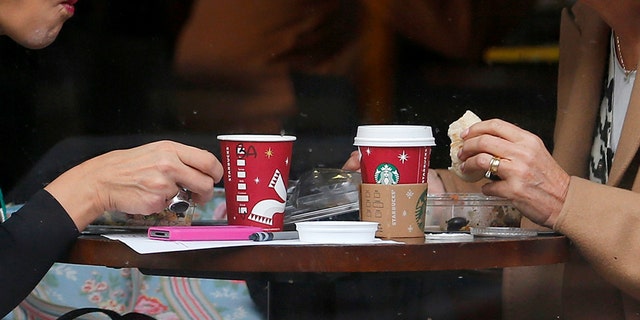 Patrons sit in a Starbucks Coffee shop in central London December 3, 2012. A committee of UK lawmakers has called on government to crack down on multinational companies that make substantial sales in Britain but pay little tax here, echoing demands from leaders across Europe for measures to tackle corporate tax avoidance. REUTERS/Andrew Winning (BRITAIN - Tags: BUSINESS POLITICS) - RTR3B5YV