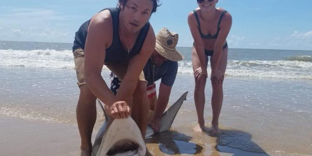 Lauren Biggers, of Conroe, Texas, poses with the blacktip shark she caught on July 7.