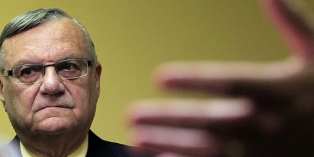 July 24, 2012: Maricopa County Sheriff Joe Arpaio listens to one of his attorneys during a news conference in Phoenix.
