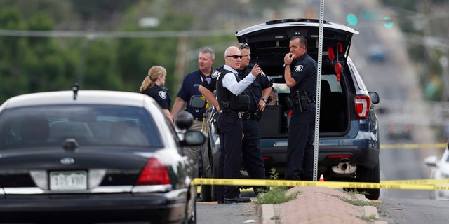 Law enforcement officials investigate around the scene of a shooting in a parking lot behind a dentist's office on Thursday, June 15, 2018.