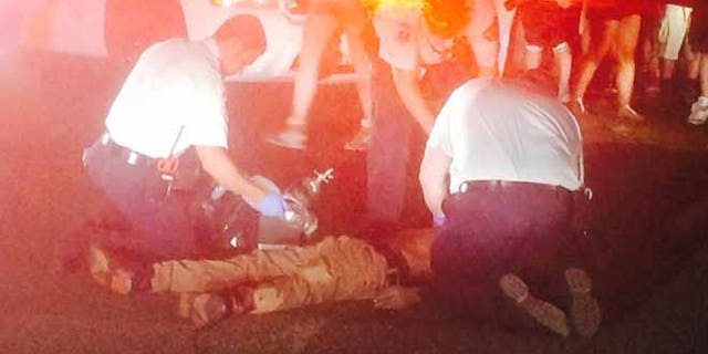 Authorities attend to people following a shooting late Monday outside the PNC Bank Arts Center.