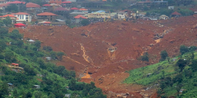 Rescue workers gather at the summit of a mudslide in Regent, east of Freetown, Sierra Leone, Monday, Aug. 14 , 2017.