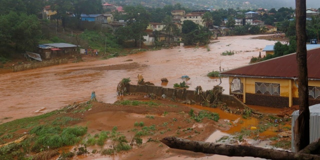 A torrent of water flows through a flooded neighbourhood in Regent, east of Freetown, Sierra Leone Monday, Aug. 14 , 2017.