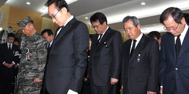South Korean President Lee Myung-bak, second from left, and his cabinet members take moment of silence during a memorial service for South Korean Marines killed in a North Korean bombardment, at a military hospital in Seongnam, South Korea, Friday, Nov. 26, 2010.
