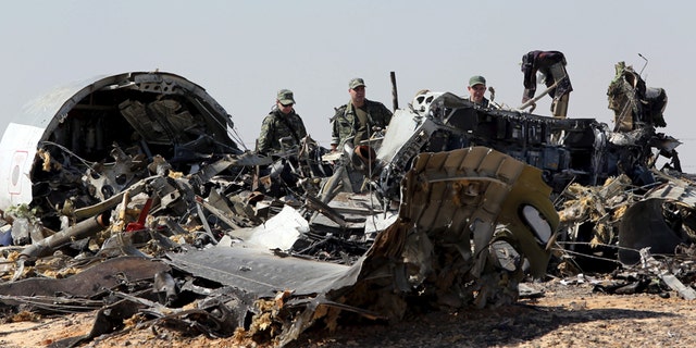 Nov. 1, 2015: Military investigators from Russia stand near the debris of a Russian airliner at the site of its crash at the Hassana area in Arish city, north Egypt.