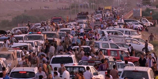 This image made from video taken on Aug. 3, 2014 shows Iraqi people from the Yazidi community arriving in Irbil in northern Iraq after Islamic militants attacked the towns of Sinjar and Zunmar.
