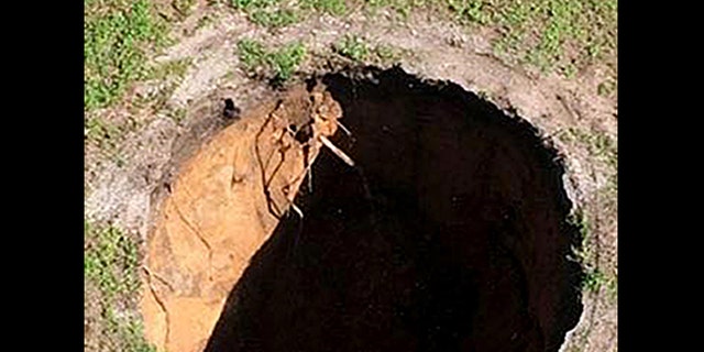 This image made from video provided by the Hillsborough County Fire Rescue, shows the property where a sinkhole reopened, Wednesday, Aug. 19, 2015, in Seffner, Fla.