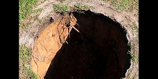 This image made from video provided by the Hillsborough County Fire Rescue, shows the property where a sinkhole reopened, Wednesday, Aug. 19, 2015, in Seffner, Fla.