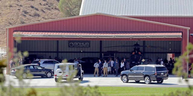 FILE - In this Wednesday, July 6, 2016 file photo, members of a film crew stand at Agua Dulce Airpark, a small, rural airport in Agua Dulce, Calif., in northern Los Angeles County. Steve de Castro, a stuntman who was injured in when he was run over by Tom Sizemore while filming the upcoming television series âShooterâ at the site on July 6 has sued the actor and Paramount Pictures over the accident in Los Angeles Superior Court on Friday, Oct. 28, 2016, stating the accident was preventable and left him with lasting injuries that have hampered his ability to work. (AP Photo/Reed Saxon)