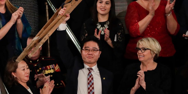 Ji Seong-ho holds up his crutches after his introduction by President Trump during the State of the Union address to a joint session of Congress on Capitol Hill in Washington, Tuesday, Jan. 30, 2018. (AP Photo/J. Scott Applewhite)