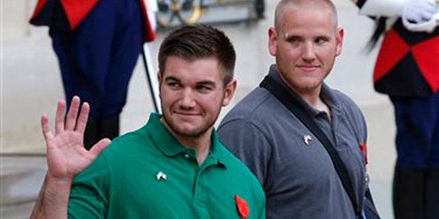 U.S. National Guardsman from Roseburg, Oregon, Alek Skarlatos , left, waves to the media as he leaves the Elysee Place in Paris, France, with U.S. Airman Spencer Stone, after being awarded with the French Legion of Honor by French President, Francois Hollande, Monday, Aug. 24, 2015. (AP Photo/Michel Euler)