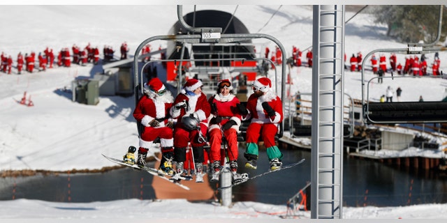 Skiers dressed as Santa Claus ride the chairlift at a resort in Newry, Maine.