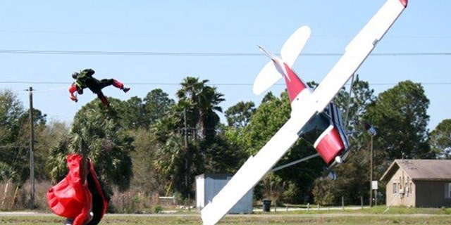 March 8, 2014: This photo released by the Polk County Sheriff's Office shows a plane nose-diving into the ground after getting tangled with a parachutist, left, at the South Lakeland Airport in Mulberry, Fla. Both the pilot and jumper hospitalized with minor injuries.