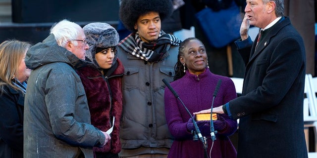 U.S. Sen. Bernie Sanders, left, administers the oath of office as New York City Mayor Bill de Blasio is sworn in for a second term, in New York City, Jan. 1, 2018.