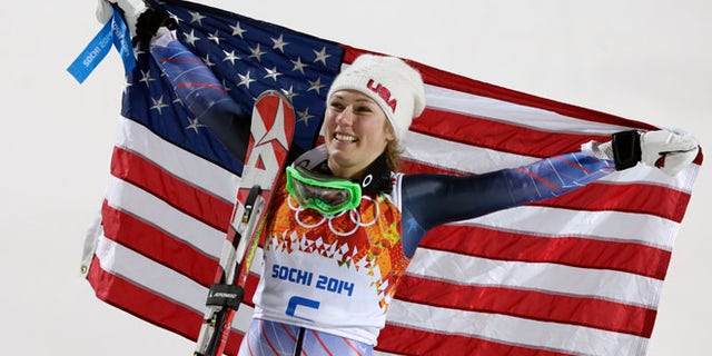 Feb. 21, 2014: Women's slalom gold medal winner Mikaela Shiffrin of the United States poses for photographers with the U.S. flag at the Sochi 2014 Winter Olympics.