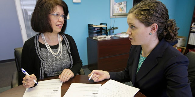 In this Jan. 22, 2014 photo, Tillie Hidalgo Lima, chief executive officer of Best Upon Request, a concierge services provider, left, works with marketing director Jessica Lima Bollin in their offices in Cincinnati. A mentoring program created by the Cincinnati USA Regional Chamber called a minority business accelerator has helped Lima get contracts with Fifth Third Bank Corp. and the Cincinnati Children's Hospital Medical Center. (AP Photo/Al Behrman)