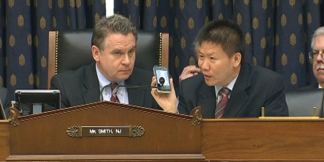 May 3, 2012: Rep. Chris Smith, left, and ChinaAid President Bob Fu, right, listen as Chinese activist Chen Guangcheng addresses a Capitol Hill committee over the phone.