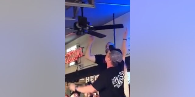 The snake wrapped itself around the bar's ceiling fan on Saturday. Staff later removed and released it.