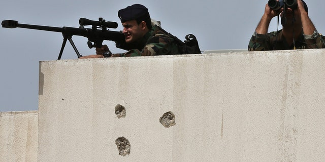 Lebanese army snipers take their positions on the top of a building, in Tripoli in 2016.