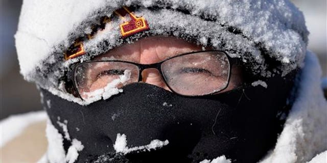 Milissa Preiss peers out from behind snow-covered glasses while clearing her Sartell, Minn., driveway Tuesday, March 3, 2015. A fast-moving storm dumped several inches of snow across the Upper Midwest on Tuesday, making travel treacherous in some areas and leading to at least several traffic-related fatalities. (AP Photo/The St. Cloud Times, Kimm Anderson)
