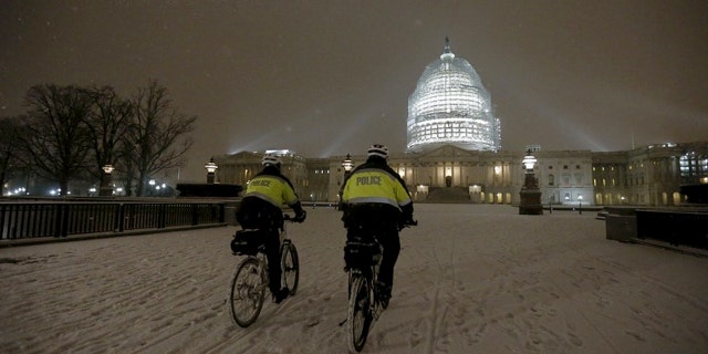 Police patrol on their bikes in Washington, D.C. on Wednesday evening as snow fell. Some predict as much as two feet of snow in Washington, D.C. --and that's on top of covering that hit the Capitol Wednesday evening.