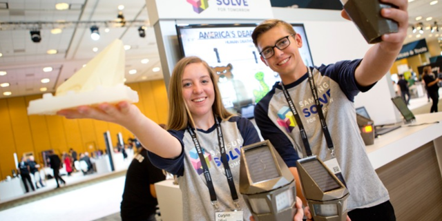 Students from Snowflake Junior High School show off their low-cost wildlife detection system that alerts drivers of animals crossing the road to mitigate accidents to attendees at the Samsung Developer Conference on October 19, 2017.