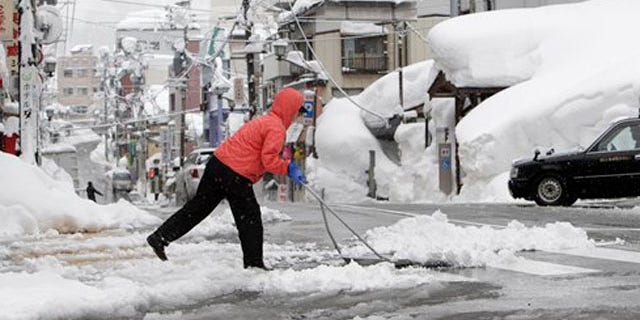 Feb. 1, 2012: A woman removes snow off a street in Yuzawa, Niigata prefecture, north of Tokyo.