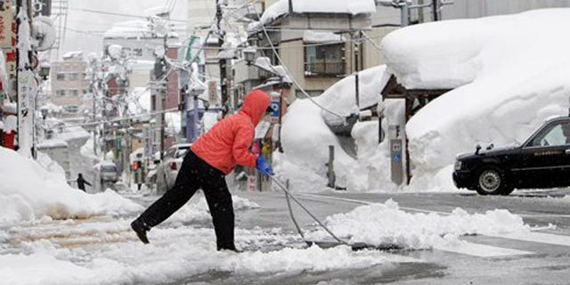 Feb. 1, 2012: A woman removes snow off a street in Yuzawa, Niigata prefecture, north of Tokyo.