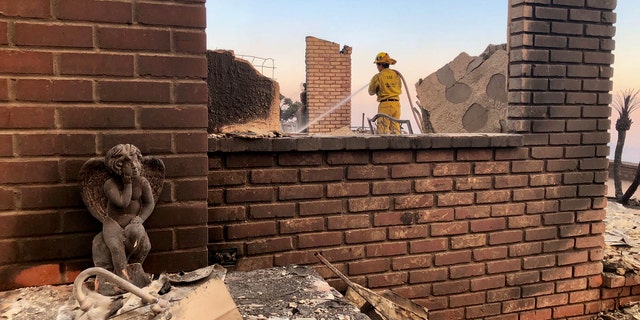 A firefighter works to douse flames from the Thomas Fire in Southern California.