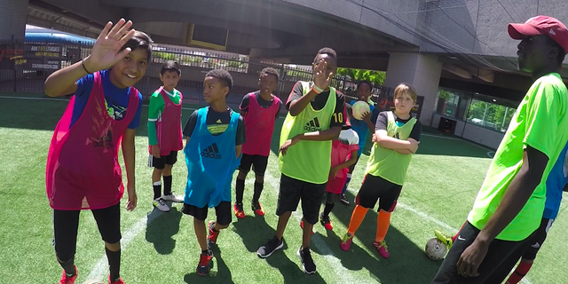 Station Soccer players wave to their friend, who wears a GoPro on his head, during their Sunday afternoon practice.