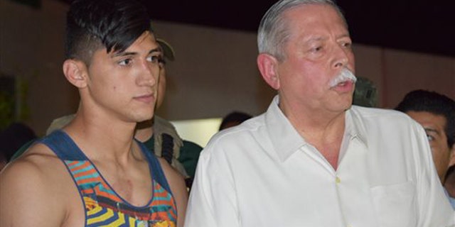 Mexican soccer player Alan Pulido, left, stands next to Tamaulipas State Gov. Egidio Torre Cantu after Pulido was rescued from kidnappers early Monday, May 30, 2016 in Ciudad Victoria, the capital of Tamaulipas State, Mexico. Mexican authorities say Pulido, a forward with Olympiacos in the Greek league, has been rescued safe and sound after an hours-long kidnapping in the northeast border state of Tamaulipas. (AP Photo/Alfredo Pena)