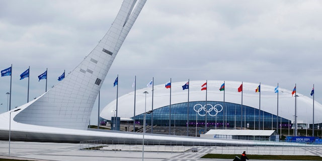 Jan. 30, 2014: A worker walks past the Olympic torch and the Bolshoy Ice Dome in the Olympic Park as construction and clean-up continues ahead of the 2014 Winter Olympics.